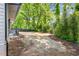 View of a newly seeded backyard, with landscaping, mature trees and stairs to a home's rear porch at 1995 Mcafee Rd, Decatur, GA 30032