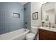 Stylish bathroom features a vanity with decorative tiles, tub-shower combo with blue tiling, and contemporary fixtures at 1995 Mcafee Rd, Decatur, GA 30032