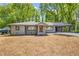 Charming gray home with a covered carport and newly landscaped front yard, set amongst mature trees at 1995 Mcafee Rd, Decatur, GA 30032