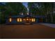 Twilight view of gray home featuring a covered carport and professionally landscaped front yard, illuminated windows at 1995 Mcafee Rd, Decatur, GA 30032