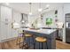Modern kitchen featuring a gray island, white cabinets, stainless steel appliances, and wood flooring at 1995 Mcafee Rd, Decatur, GA 30032