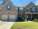 Charming two-story brick home featuring an attached two-car garage, covered porch and lush landscaping at 200 Birchwood Dr, Loganville, GA 30052