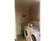 Functional laundry room with washer, dryer, and storage cabinets at 200 Birchwood Dr, Loganville, GA 30052