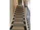 Carpeted stairway with decorative wrought iron railing leading to the upper level at 200 Birchwood Dr, Loganville, GA 30052