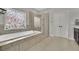 Bathroom featuring tile floors, a tub, a walk-in shower, and a decorative stained-glass window at 2740 Longacre Park Way, Lawrenceville, GA 30044