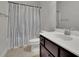 Bright bathroom featuring a single vanity, toilet, and a shower with a blue-striped curtain at 2740 Longacre Park Way, Lawrenceville, GA 30044