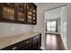 Kitchen counter with dark wood cabinets and granite countertops that leads into a dining area at 2740 Longacre Park Way, Lawrenceville, GA 30044