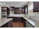 Spacious kitchen featuring dark wood cabinets, granite countertops, and stainless steel appliances at 2740 Longacre Park Way, Lawrenceville, GA 30044