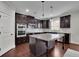 Elegant kitchen featuring dark wood cabinets, granite countertops, and modern appliances at 2740 Longacre Park Way, Lawrenceville, GA 30044