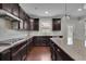 Modern kitchen with dark wood cabinets, granite countertops, and stainless steel appliances at 2740 Longacre Park Way, Lawrenceville, GA 30044