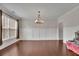 This living room features hardwood floors, decorative trim, a hanging light fixture and lots of natural light at 2740 Longacre Park Way, Lawrenceville, GA 30044
