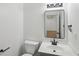 Modern half bathroom features a sleek black faucet, mirror, and fixtures, complemented by a gray vanity at 1097 Soaring Way, Marietta, GA 30062