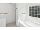 Bright bathroom with a soaking tub under a large window, tile floors, and black hardware at 1097 Soaring Way, Marietta, GA 30062