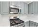 Updated kitchen features stainless steel appliances, stylish gray cabinets, and white subway tile backsplash at 1097 Soaring Way, Marietta, GA 30062