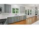 Open kitchen with stainless appliances, gray cabinets, white countertop, and connected to living area at 1097 Soaring Way, Marietta, GA 30062