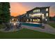 Inviting backyard with a pool, fire pit, covered seating, and an illuminated multi-story home at 3330 Riverwalk Way, Cumming, GA 30040