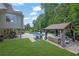 Beautiful backyard with a covered patio, swimming pool, and landscaped lawn at 3330 Riverwalk Way, Cumming, GA 30040