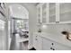 Hallway showcasing built-in cabinets with glass doors and sleek countertops, leading to an elegant dining area at 3330 Riverwalk Way, Cumming, GA 30040