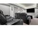 Home theater with black reclining chairs facing flat screen TV at 3330 Riverwalk Way, Cumming, GA 30040
