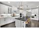 Bright kitchen features white cabinets, stainless steel appliances, large island, and stylish pendant lighting at 3330 Riverwalk Way, Cumming, GA 30040