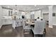 Well-lit kitchen with an island, white cabinetry, stainless steel appliances, and a dining area at 3330 Riverwalk Way, Cumming, GA 30040
