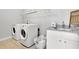Bright laundry room with white washer and dryer, utility sink, basket and plenty of storage space at 3330 Riverwalk Way, Cumming, GA 30040
