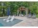 Inviting pool area featuring lounge chairs, a covered gazebo, and travertine decking at 3330 Riverwalk Way, Cumming, GA 30040