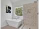 Bathroom with sleek tub and modern shower featuring decorative tile and modern fixtures at 4999 Willow Creek Dr, Woodstock, GA 30188