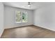 Neutral bedroom with a ceiling fan, large window, and light wood floors at 4999 Willow Creek Dr, Woodstock, GA 30188