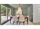 Cozy dining room featuring neutral walls, natural light, modern light fixture, and wood table with upholstered chairs at 4999 Willow Creek Dr, Woodstock, GA 30188