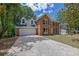 Classic two-story brick home with a two-car garage, dormers, a traditional facade, and mature shade trees at 4999 Willow Creek Dr, Woodstock, GA 30188