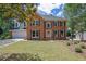Charming two-story brick home with a well-manicured lawn, classic shutters, and an attached two-car garage at 4999 Willow Creek Dr, Woodstock, GA 30188