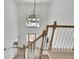 Bright hallway boasts a modern light fixture and staircase with views of the entryway below at 4999 Willow Creek Dr, Woodstock, GA 30188