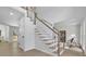 Bright entry foyer with a staircase featuring white banisters and stained handrail plus light wood-look floors at 4999 Willow Creek Dr, Woodstock, GA 30188