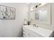 Elegant powder room with white vanity, brass fixtures, and charming floral art at 1027 Riverbend Club Se Dr, Atlanta, GA 30339