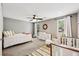 Bedroom with neutral decor, ceiling fan, and a crib with a nearby changing table at 1027 Riverbend Club Se Dr, Atlanta, GA 30339