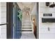 Inviting entryway with white tile and wood stairs, featuring an open door, mail slot, and wreath at 1027 Riverbend Club Se Dr, Atlanta, GA 30339