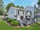 Well-manicured backyard with deck, green lawn and landscaping surrounding the home at 1027 Riverbend Club Se Dr, Atlanta, GA 30339