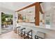 Open kitchen with breakfast bar, white cabinets, wooden beams, and outdoor deck access at 1027 Riverbend Club Se Dr, Atlanta, GA 30339