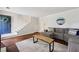 Spacious living area with hardwood floors, a cozy grey sectional sofa, and an inviting open doorway at 1027 Riverbend Club Se Dr, Atlanta, GA 30339