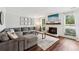 Bright living room with a cozy fireplace, hardwood floors, and a comfortable grey sectional sofa at 1027 Riverbend Club Se Dr, Atlanta, GA 30339