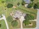 Aerial view of the home, with a spacious lawn, mature trees, long driveway, and well-manicured landscaping at 105 Whippoorwill Way, Fayetteville, GA 30215