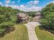 Aerial view of the property showcasing lush landscaping, mature trees, and a spacious driveway leading to a three-car garage at 105 Whippoorwill Way, Fayetteville, GA 30215
