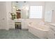 Relaxing bathroom featuring a soaking tub, vanity area, and bright window at 105 Whippoorwill Way, Fayetteville, GA 30215