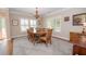 Bright dining room featuring a large wooden table, chandelier, and ample natural light at 105 Whippoorwill Way, Fayetteville, GA 30215
