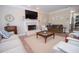 Cozy living room featuring a fireplace, comfortable seating, and a seamless transition to the kitchen area at 105 Whippoorwill Way, Fayetteville, GA 30215