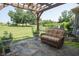 Outdoor patio with a wooden pergola, stone floor, and comfortable seating overlooking a manicured lawn at 105 Whippoorwill Way, Fayetteville, GA 30215