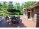 Wide shot of outdoor deck featuring an outdoor dining set and a cozy couch at 2101 Hunters Green Dr, Lawrenceville, GA 30043