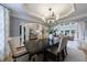 Open-concept dining room with modern chandelier, neutral color palette, and large windows at 2101 Hunters Green Dr, Lawrenceville, GA 30043