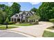 Well-manicured lawn and garden of a two-story home, surrounded by mature trees and green space at 2101 Hunters Green Dr, Lawrenceville, GA 30043